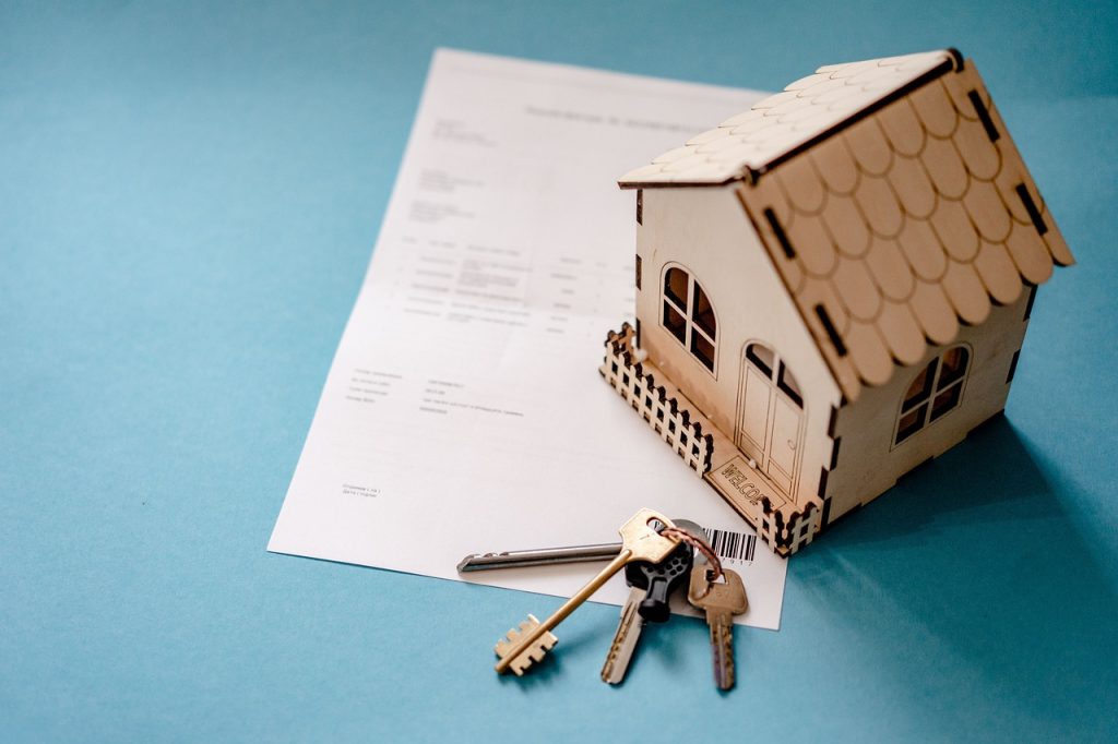 Documents juridiques et clés de maison sur un bureau pour dissoudre une SCI