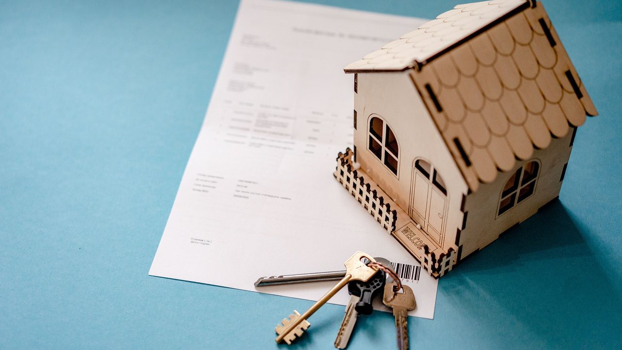 Documents juridiques et clés de maison sur un bureau pour dissoudre une SCI