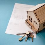Documents juridiques et clés de maison sur un bureau pour dissoudre une SCI
