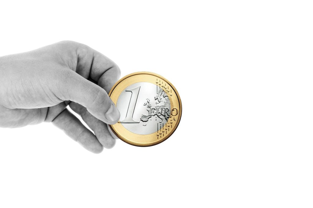 Boîte de dons remplie de pièces illustrant la fiscalité des dons aux associations