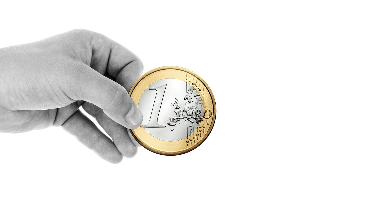 Boîte de dons remplie de pièces illustrant la fiscalité des dons aux associations