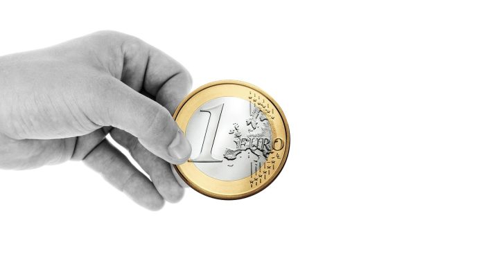 Boîte de dons remplie de pièces illustrant la fiscalité des dons aux associations