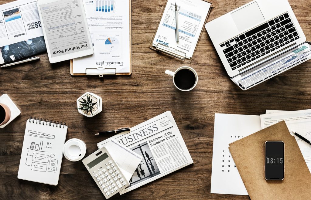 Calculatrice posée sur des relevés boursiers pour calculer la fiscalité des plus-values mobilières