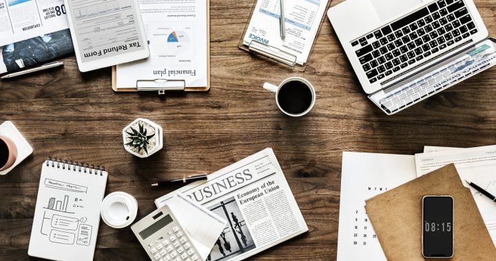 Calculatrice posée sur des relevés boursiers pour calculer la fiscalité des plus-values mobilières