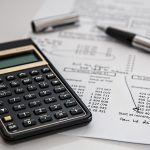 Alliance posée sur des documents administratifs à côté d'une calculatrice pour l'allocation veuvage